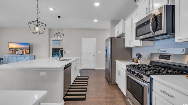 356 Ocean Commons Dr, Surfside Beach, SC 29575 - kitchen with stainless steel appliances, a center island with sink, dark wood finished floors, light countertops, and white cabinetry