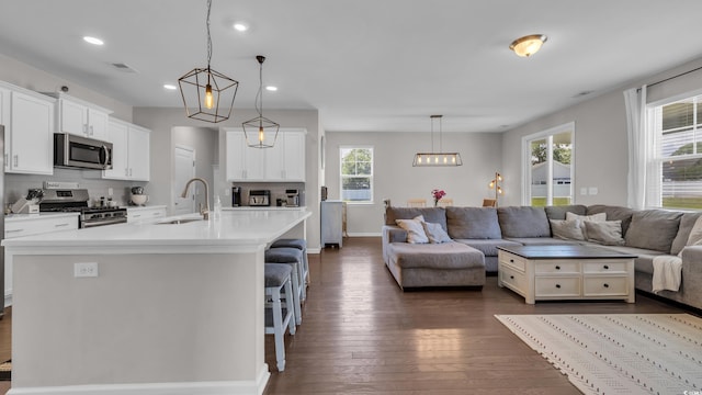 356 Ocean Commons Dr, Surfside Beach, SC 29575 - kitchen with appliances with stainless steel finishes, open floor plan, dark wood-type flooring, a breakfast bar area, and an island with sink
