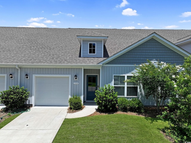 184 Sea Shell Dr Unit 12, Murrells Inlet, SC 29576 - view of front of house featuring a shingled roof, a front yard, concrete driveway, a garage, and board and batten siding
