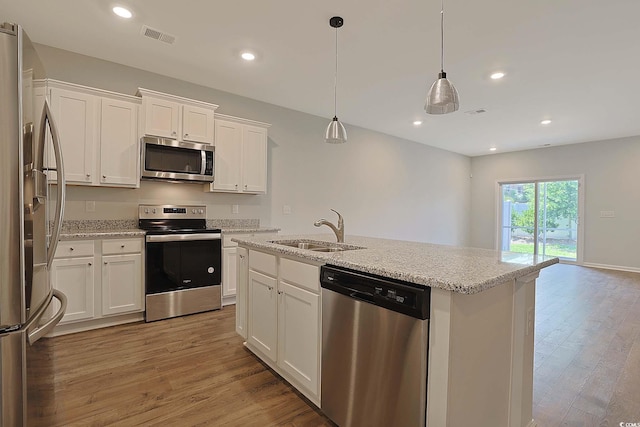 184 Sea Shell Dr Unit 12, Murrells Inlet, SC 29576 - kitchen with stainless steel appliances, white cabinetry, light wood-style flooring, a center island with sink, and light stone counters