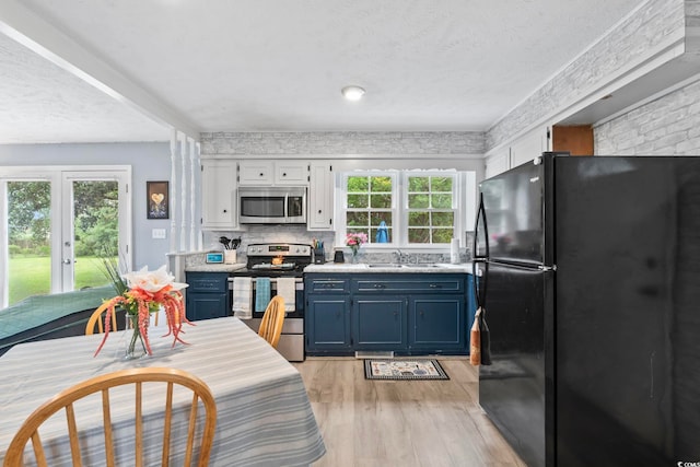 169 Ole Maple St, Loris, SC 29569 - kitchen with stainless steel appliances, blue cabinets, light wood-style flooring, light countertops, and a textured ceiling
