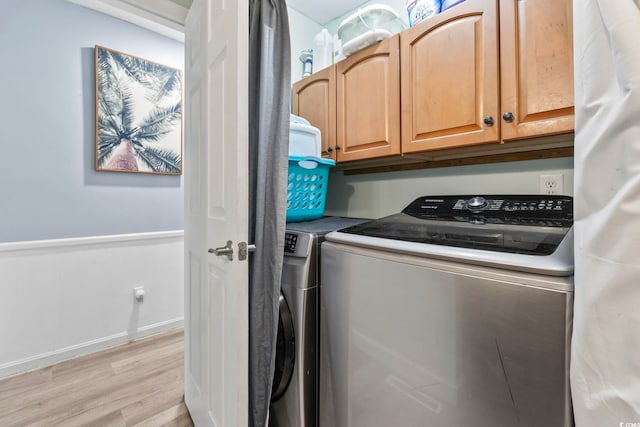 169 Ole Maple St, Loris, SC 29569 - laundry area with independent washer and dryer, light wood-style floors, wainscoting, and cabinet space
