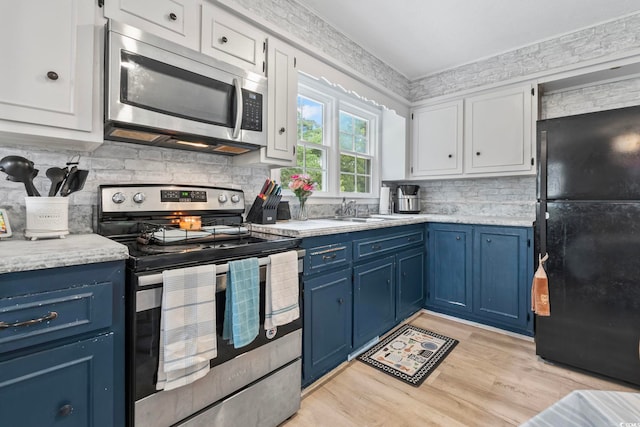 169 Ole Maple St, Loris, SC 29569 - kitchen with appliances with stainless steel finishes, blue cabinets, white cabinetry, tasteful backsplash, and light wood-style floors