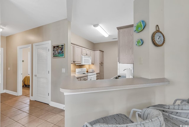 876 Palmetto Trl Unit 103, Myrtle Beach, SC 29577 - kitchen with white appliances, light tile patterned floors, light countertops, a peninsula, and decorative backsplash