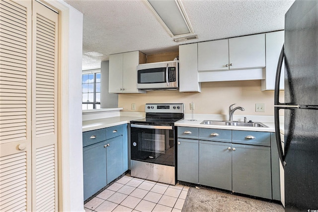 6703 Jefferson Pl Unit G5, Myrtle Beach, SC 29572 - kitchen with appliances with stainless steel finishes, a textured ceiling, light countertops, light tile patterned flooring, and blue cabinetry