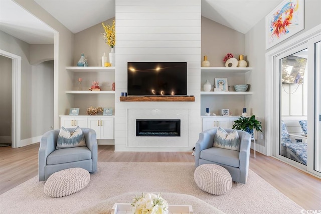 558 Oxbow Dr, Myrtle Beach, SC 29579 - living area with vaulted ceiling, a large fireplace, light wood-style floors, and built in shelves