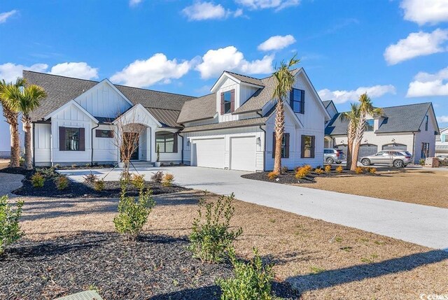 558 Oxbow Dr, Myrtle Beach, SC 29579 - modern farmhouse style home featuring board and batten siding, a garage, driveway, and roof with shingles