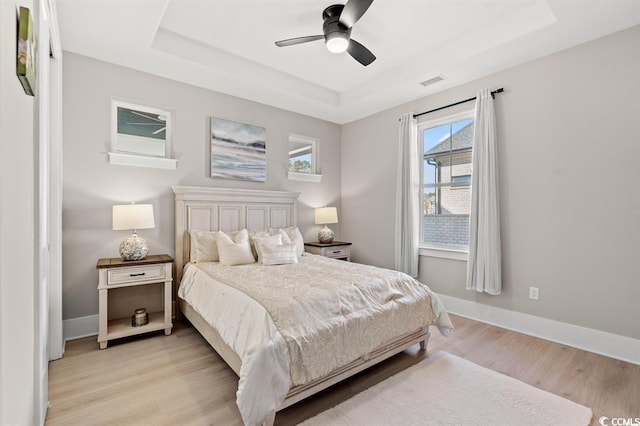 558 Oxbow Dr, Myrtle Beach, SC 29579 - bedroom with a tray ceiling, light wood-style flooring, and a ceiling fan