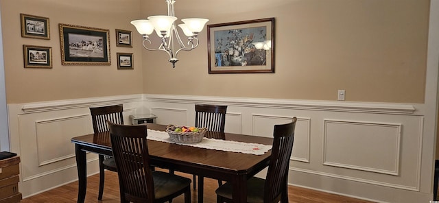 309 Outboard Dr, Murrells Inlet, SC 29576 - dining space with a chandelier, dark wood-style floors, a decorative wall, and wainscoting