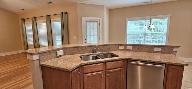 309 Outboard Dr, Murrells Inlet, SC 29576 - kitchen with stainless steel dishwasher, a center island with sink, hanging light fixtures, light stone counters, and light wood finished floors