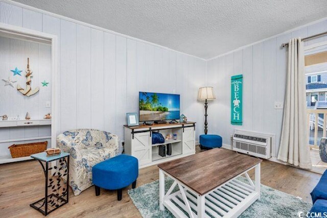 4201 N Ocean Blvd Unit 2M, North Myrtle Beach, SC 29582 - living room featuring an AC wall unit, wood finished floors, and a textured ceiling