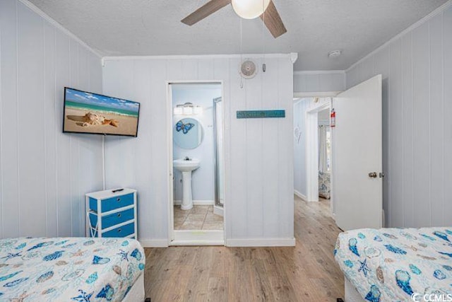 4201 N Ocean Blvd Unit 2M, North Myrtle Beach, SC 29582 - bedroom with wood finished floors, crown molding, a ceiling fan, a textured ceiling, and connected bathroom