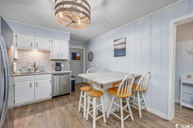 4201 N Ocean Blvd Unit 2M, North Myrtle Beach, SC 29582 - kitchen featuring stainless steel appliances, light wood finished floors, a textured ceiling, white cabinets, and light countertops