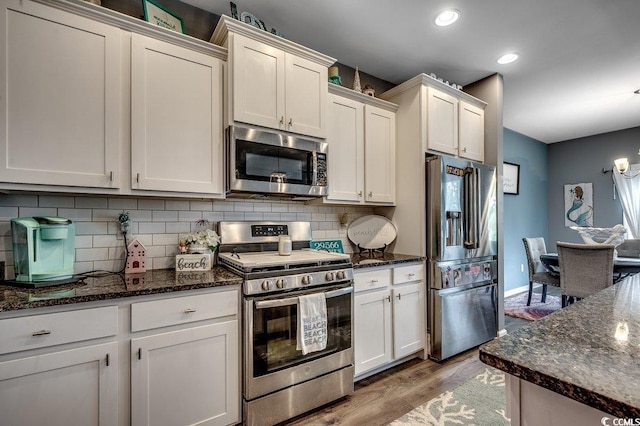 153 Goldenrod Cir Unit 7D, Little River, SC 29566 - kitchen with appliances with stainless steel finishes, light wood-type flooring, backsplash, recessed lighting, and dark stone countertops