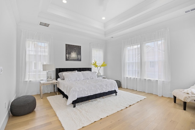 2313 Summersweet Ln, Myrtle Beach, SC 29579 - bedroom featuring a tray ceiling, multiple windows, light wood-style flooring, ornamental molding, and recessed lighting