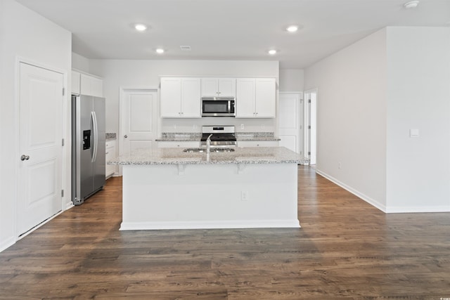 3657 Bells Lake Cir, Longs, SC 29568 - kitchen featuring appliances with stainless steel finishes, light stone counters, a kitchen island with sink, recessed lighting, and dark wood-type flooring