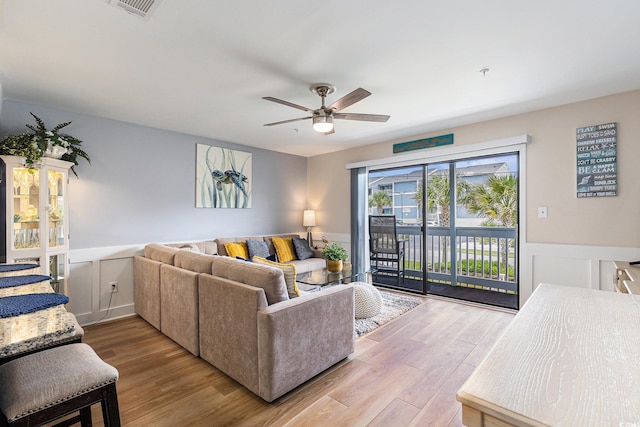 1210 N Ocean Blvd Unit 104, Surfside Beach, SC 29575 - living room with ceiling fan, a wainscoted wall, wood finished floors, and a decorative wall