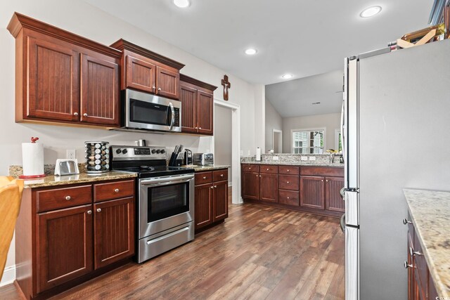 144 Baylee Cir, Aynor, SC 29544 - kitchen with appliances with stainless steel finishes, dark wood finished floors, recessed lighting, light stone counters, and lofted ceiling