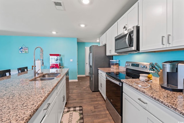 798 Woodland Farms Cir, Aynor, SC 29511 - kitchen featuring appliances with stainless steel finishes, dark wood-style floors, white cabinetry, recessed lighting, and light stone countertops