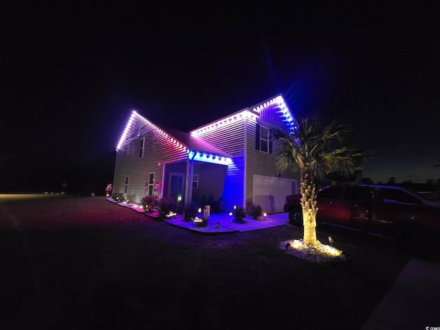 798 Woodland Farms Cir, Aynor, SC 29511 - back of house at twilight with an attached garage, driveway, and a fire pit