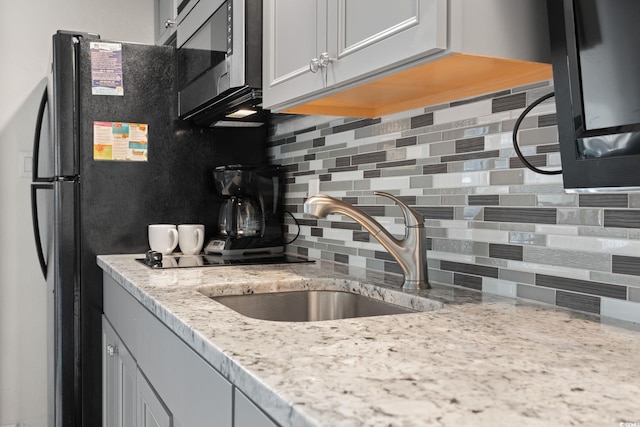 4800 S Ocean Blvd Unit 920, North Myrtle Beach, SC 29582 - kitchen featuring stainless steel microwave, decorative backsplash, and light stone counters