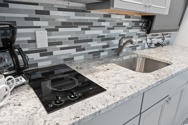 4800 S Ocean Blvd Unit 920, North Myrtle Beach, SC 29582 - kitchen featuring backsplash, black electric stovetop, light stone counters, and white cabinetry