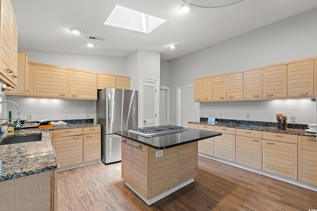 149 Old Cedar Loop, Pawleys Island, SC 29585 - kitchen featuring light brown cabinets, appliances with stainless steel finishes, light wood-style flooring, a skylight, and vaulted ceiling