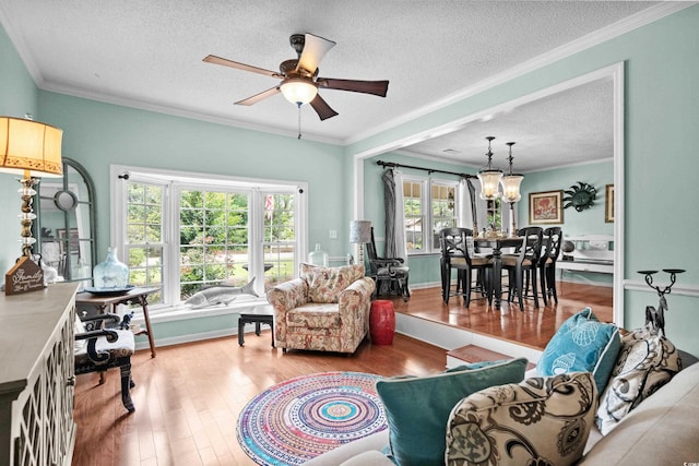280 Morgan Ave, Little River, SC 29566 - living area featuring a textured ceiling, wood finished floors, a chandelier, a ceiling fan, and crown molding