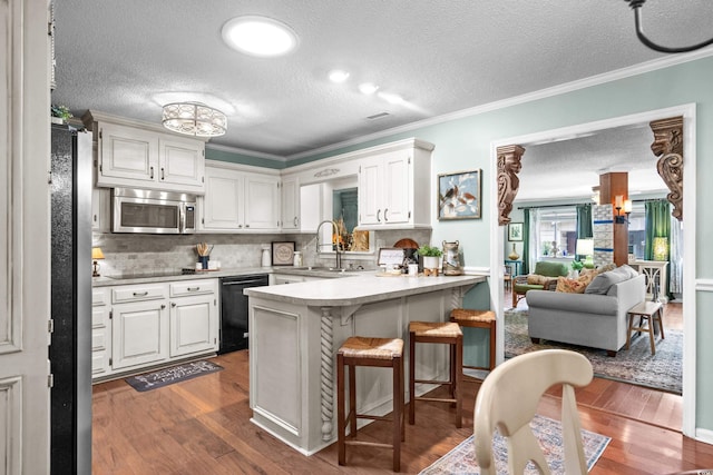 280 Morgan Ave, Little River, SC 29566 - kitchen with black appliances, a peninsula, dark wood-style flooring, a breakfast bar area, and crown molding