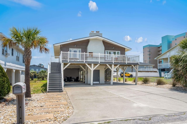 204 55th Ave N, North Myrtle Beach, SC 29582 - view of front of property featuring stairway, a carport, driveway, a porch, and a chimney