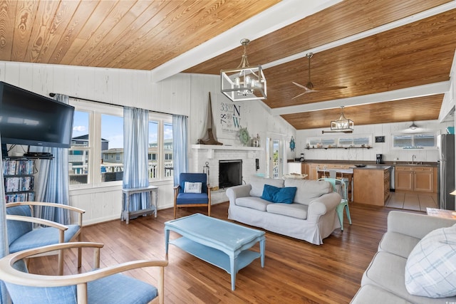 204 55th Ave N, North Myrtle Beach, SC 29582 - living room with wooden ceiling, a chandelier, wood-type flooring, a brick fireplace, and wood walls