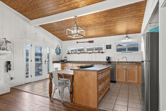 204 55th Ave N, North Myrtle Beach, SC 29582 - kitchen featuring appliances with stainless steel finishes, wooden ceiling, wood walls, a kitchen bar, and a kitchen island