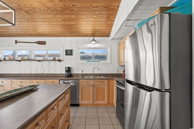 204 55th Ave N, North Myrtle Beach, SC 29582 - kitchen featuring appliances with stainless steel finishes, light tile patterned floors, dark countertops, brown cabinets, and wooden walls