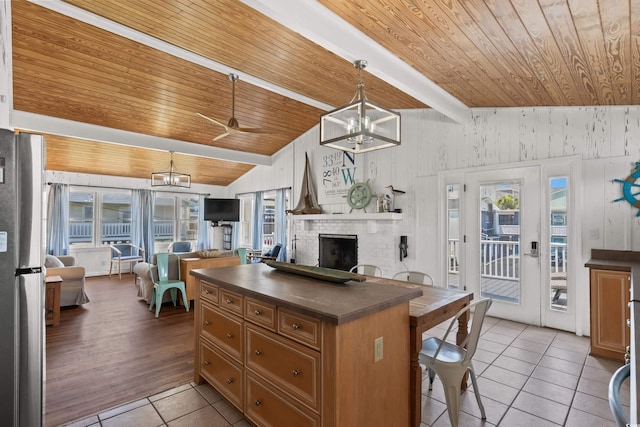 204 55th Ave N, North Myrtle Beach, SC 29582 - kitchen featuring wood ceiling, a chandelier, dark countertops, light tile patterned floors, and a brick fireplace