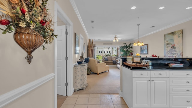 4142 Hibiscus Dr Unit 102, Little River, SC 29566 - kitchen featuring light colored carpet, light tile patterned floors, dark countertops, crown molding, and white cabinets