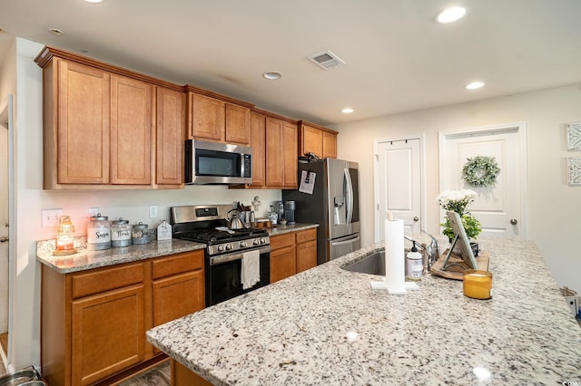 247GROVEPARK Grove Park Loop, Murrells Inlet, SC 29576 - kitchen featuring stainless steel appliances, recessed lighting, a center island with sink, light stone countertops, and brown cabinets