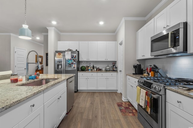 1078 Saltgrass Way, Myrtle Beach, SC 29588 - kitchen with appliances with stainless steel finishes, backsplash, ornamental molding, wood finished floors, and white cabinetry
