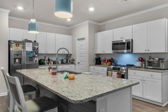 1078 Saltgrass Way, Myrtle Beach, SC 29588 - kitchen with stainless steel appliances, light wood-style floors, a breakfast bar area, white cabinets, and tasteful backsplash