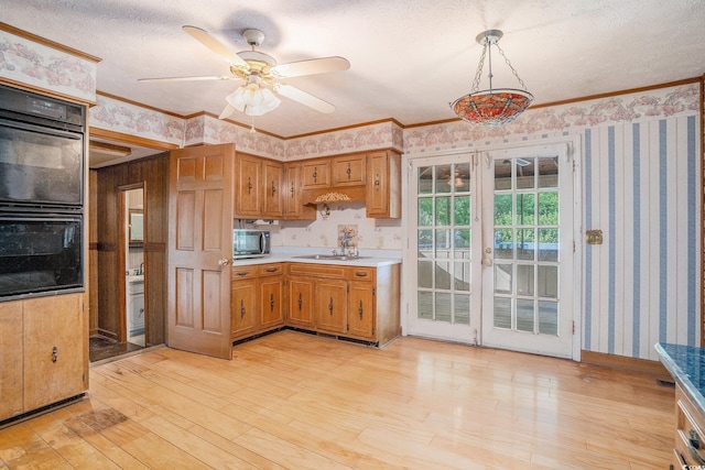4920 Meadow St, Loris, SC 29569 - kitchen featuring wallpapered walls, stainless steel microwave, light countertops, light wood finished floors, and ceiling fan