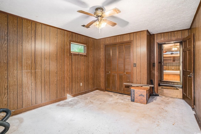 4920 Meadow St, Loris, SC 29569 - unfurnished bedroom featuring unfinished concrete flooring, wood walls, a closet, ceiling fan, and ornamental molding