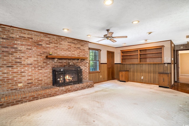 4920 Meadow St, Loris, SC 29569 - unfurnished living room with ceiling fan, a brick fireplace, a textured ceiling, recessed lighting, and wooden walls