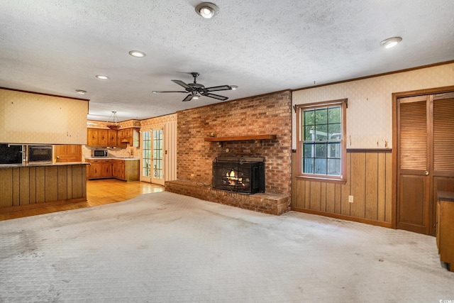 4920 Meadow St, Loris, SC 29569 - unfurnished living room with a wood stove, ceiling fan, a textured ceiling, crown molding, and wainscoting