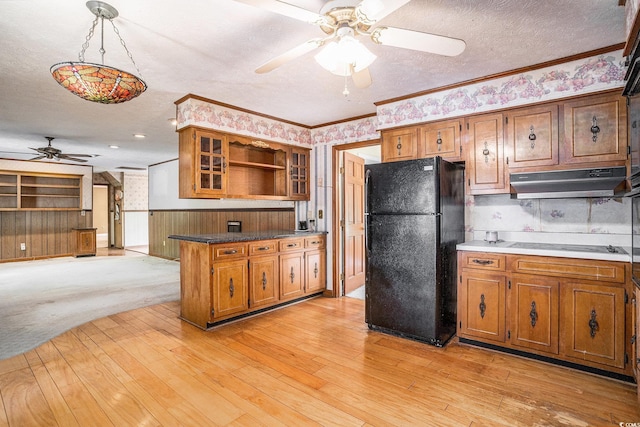 4920 Meadow St, Loris, SC 29569 - kitchen featuring freestanding refrigerator, a ceiling fan, under cabinet range hood, brown cabinetry, and open shelves