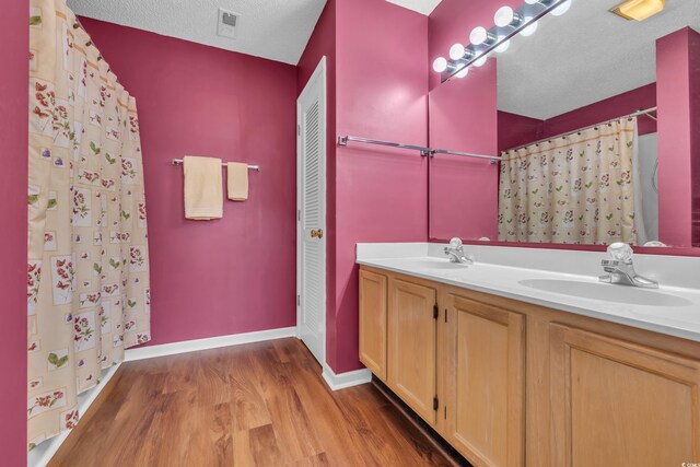 1206 Formby Ct, Myrtle Beach, SC 29588 - bathroom featuring wood finished floors, double vanity, a shower with curtain, and a textured ceiling
