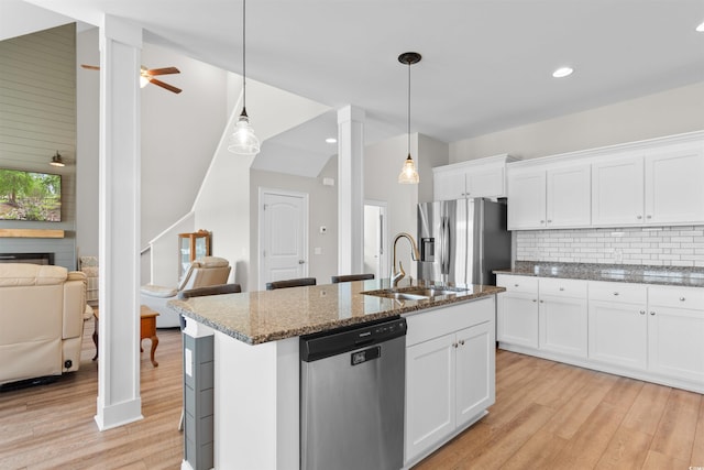 3617 Pasture Rd, Aynor, SC 29511 - kitchen with appliances with stainless steel finishes, light wood finished floors, tasteful backsplash, dark stone counters, and white cabinets