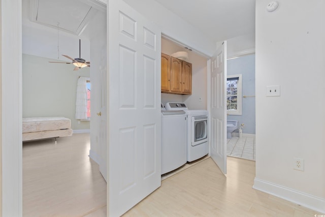 4552 River Rd, Little River, SC 29566 - laundry room featuring washing machine and dryer, cabinet space, attic access, light wood-style floors, and healthy amount of natural light