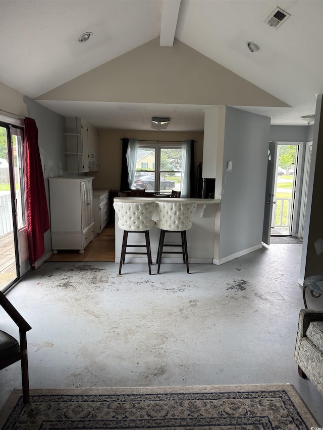 3534 Gordon Dr, Myrtle Beach, SC 29579 - kitchen featuring vaulted ceiling, a breakfast bar, and fridge