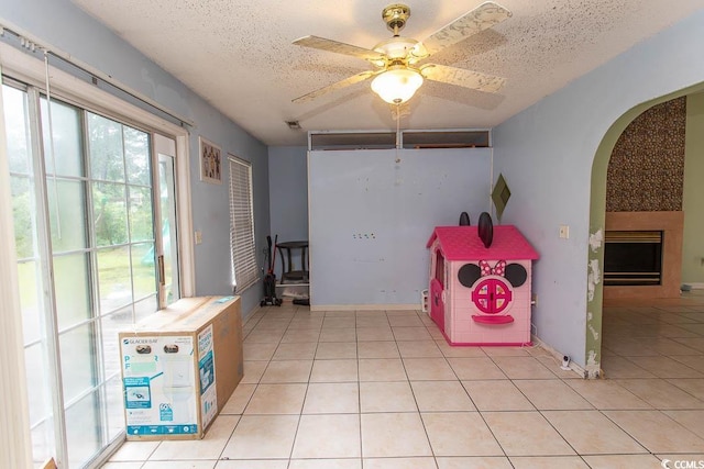 318 Muirfield Rd, Myrtle Beach, SC 29588 - playroom with arched walkways, a textured ceiling, light tile patterned flooring, and a ceiling fan