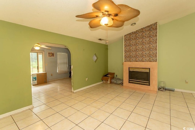 318 Muirfield Rd, Myrtle Beach, SC 29588 - unfurnished living room with arched walkways, ceiling fan, light tile patterned flooring, and a large fireplace