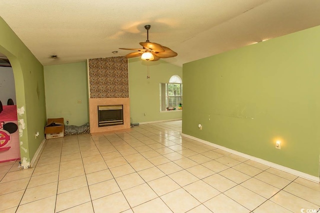 318 Muirfield Rd, Myrtle Beach, SC 29588 - unfurnished living room with a ceiling fan, a large fireplace, light tile patterned floors, vaulted ceiling, and arched walkways